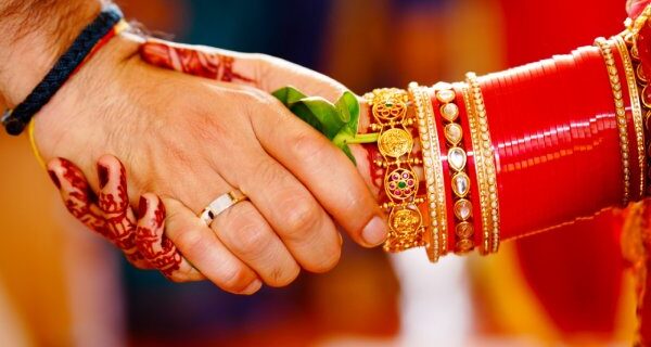 A photograph capturing the handshake between the bride and groom during a traditional Kerala-style wedding ritual, taken by Sidphoto photographer.