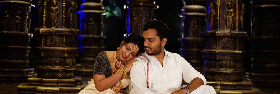 South Indian couple in traditional Kanjeevaram saree and veshti posing near Meenakshi Temple during a cultural pre-wedding photoshoot.
